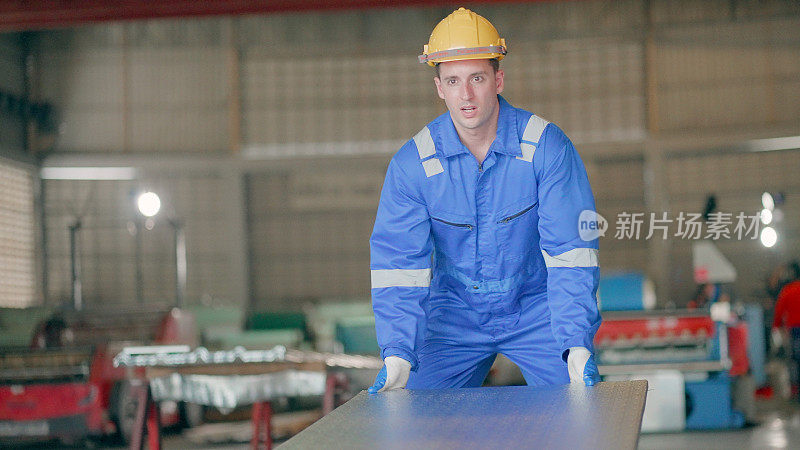 Production line worker or industrial engineer or technician, working in metal manufacturing factory or heavy industry, move and checking the quality of produce on the conveyor coming out of the machine รื steel processing plant.